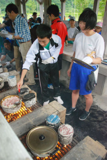 両町の子どもたちが協力して野外炊飯に取り組んだ＝7日、庄内町立谷沢