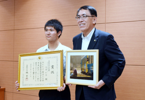 全国総文祭写真部門で最高賞を受けた佐藤さん（左）。丸山市長が手にしているのが受賞作