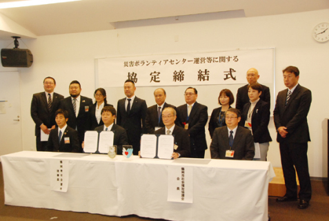 協定書を手にする山木会長（中央右）と佐藤理事長（同左）を囲む両団体の役員ら