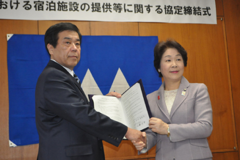 握手を交わして協定締結を喜ぶ佐藤理事長（左）と吉村知事