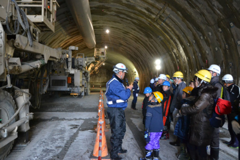 日沿道「朝日温海道路」の大岩川トンネル内で、掘削現場を見学する参加者たち