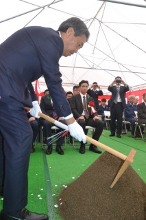 鶴岡で初となる大型風力発電施設の起工式で、くわ入れする竹内ＪＲＥ社長