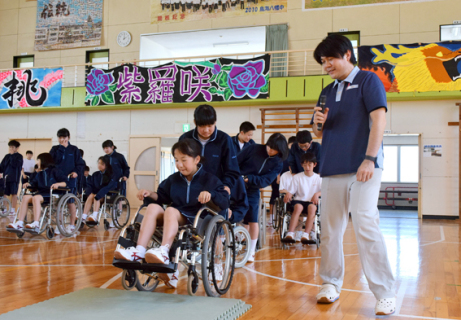 矢島さん（右）の指導で車椅子操作を学ぶ生徒たち