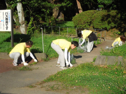 鶴岡「小さな親切」の会のクリーン大作戦で除草作業を行う参加者たち