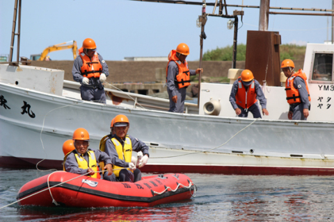 救助を求める漁船へ岸壁からロープを渡し、ゴムボートでけが人救出を展開した訓練