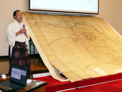 鶴ケ岡城の大きな古地図を示しながら話した石原宮司