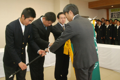 選抜旗を受け取る（左から）鈴木主将、佐藤監督、齋藤校長