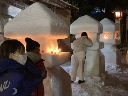 雪灯篭に願いを掛ける観光客