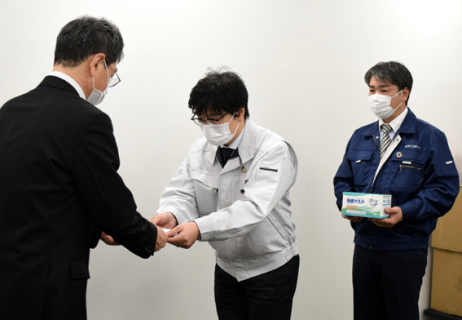 菊池部長（左）に目録を手渡す佐藤優社長（中央）＝15日午前、酒田市庁舎