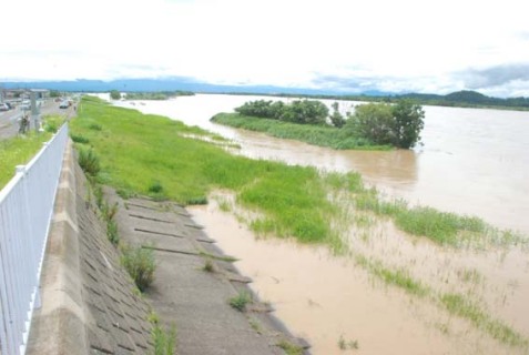 氾濫危険水域を超えて河川敷まで浸水した最上川＝29日午前11時、出羽大橋付近から