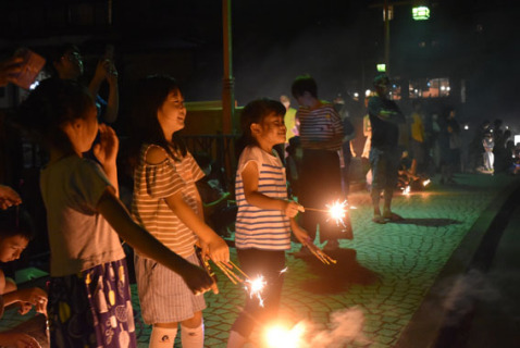 夏休み中の地元の子どもたちが集まり、手持ち花火をしながら天魄山から打ち上がる花火を楽しんだ