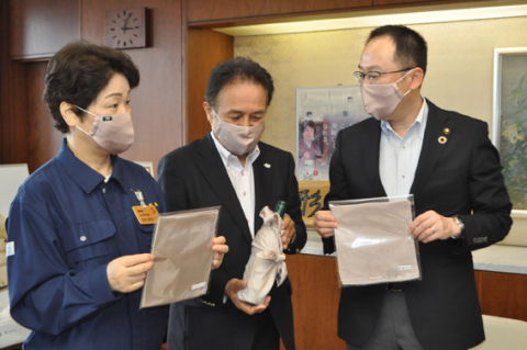 ワイン染めのマスクを着け、吉村知事（左）に商品のお披露目をする太田組合長（中央）と皆川市長