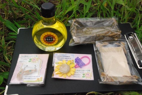 ヒマワリを使った製品。左奥から左回りにヒマワリ油の試作品、ヒマワリ紙のイヤリング、ブローチ、小箱