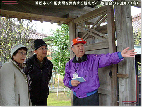 浜松市の年配夫婦を案内する観光ガイド協議会の安達さん（右）