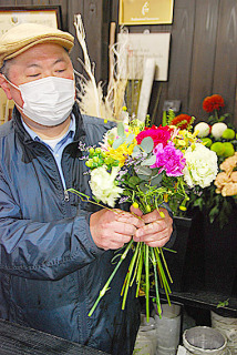 予約注文が入った「母の日」用の花束を作る三浦さん＝7日午前、鶴岡市の花蔵