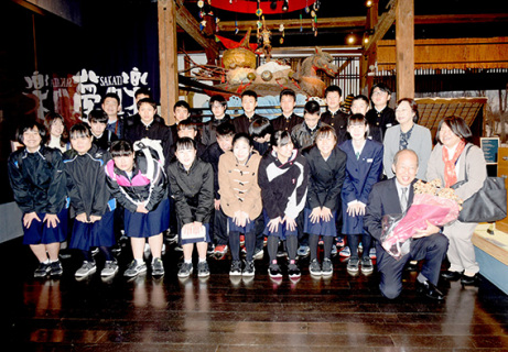 記念写真に収まる村田二中の生徒たち。前列右でドライフラワーを持つ荒生専務