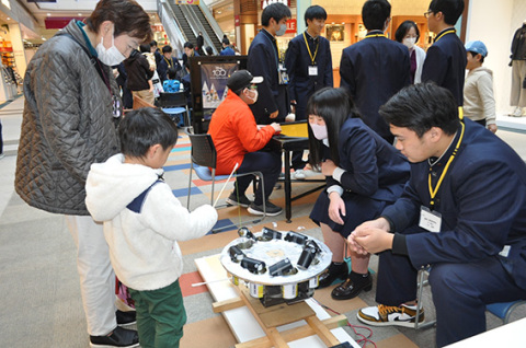 「そこだ、頑張って！」と、魚釣りゲームを楽しむ子どもを生徒たちが応援