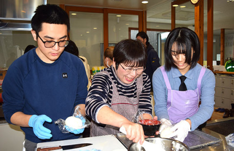 土門さん（中央）の指導で郷土料理にチャレンジする松下さん（左）と片山さん