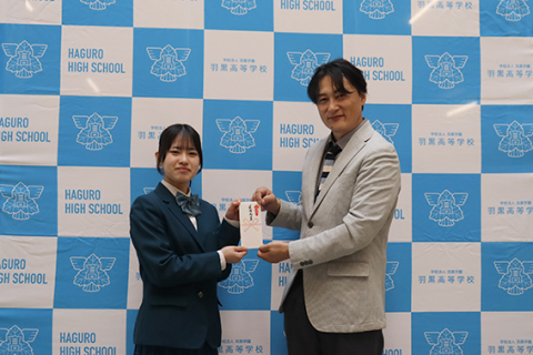 デザインが採用された高橋さん（左）と田村社長＝羽黒高校