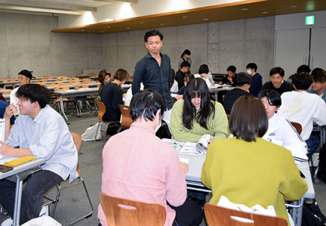 渡邊さん（中央）の指導でグループワークに取り組む受講学生たち＝17日