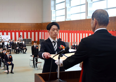 佐藤校長（右）から卒業証書を受け取る卒業生