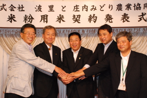 藤波社長（左から2人目）と阿部組合長（中央）ら関係者が手を重ねて今後の協力を誓った