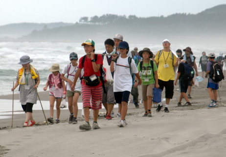 遊佐町内の砂浜を歩くわんぱく自然塾の参加者たち＝5日午後4時半ごろ、十里塚海岸
