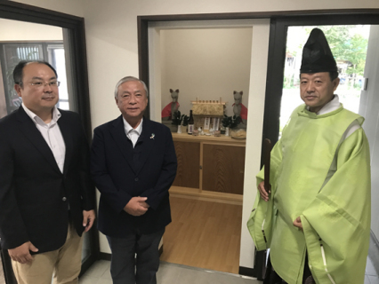 出入り口付近にはお稲荷様が鎮座。5日の竣工式に参列した芳賀さん（中央）と北風社長（左）。祭主を務めた荘内神社の石原純一宮司は「多くの人にお稲荷様の頭をなでてめでてもらいたい」