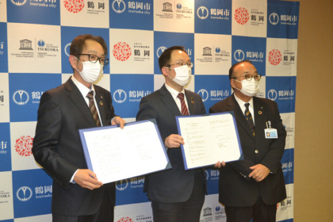 マスク供給の協定書に署名した左から長谷川社長、皆川市長、冨樫会長